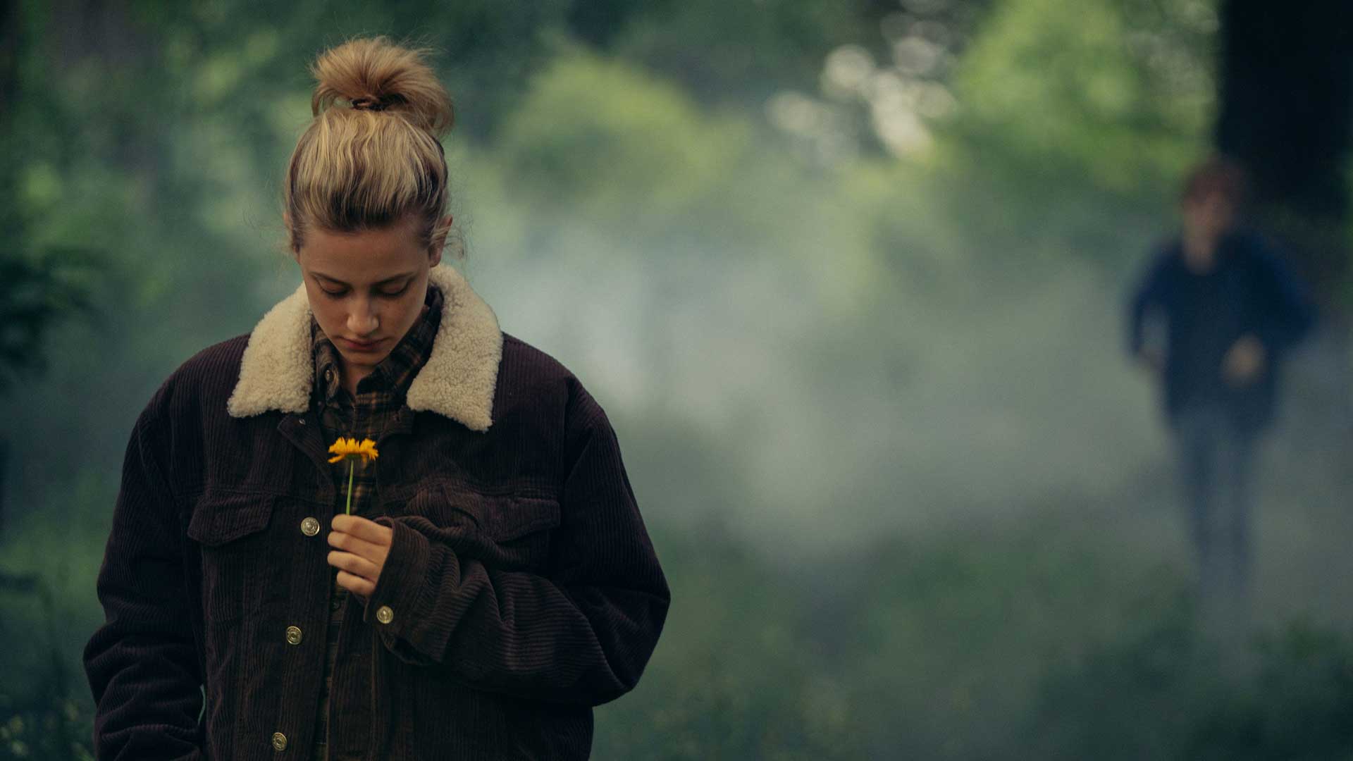 لی لی راینهارت مشغول نگاه کردن به گل زردرنگ داخل جنگه مه آلود فیلم رمانتیک Chemical Hearts