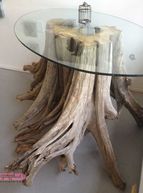 میز شیشه ای زیبا با تنه درخت بزرگ در اتاق پذیرایی